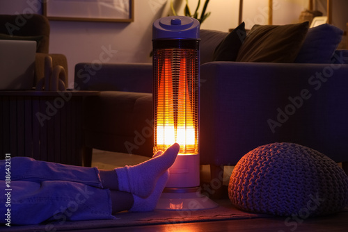Young woman warming feet ne...