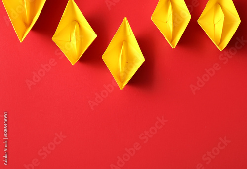Yellow paper boats on red b...