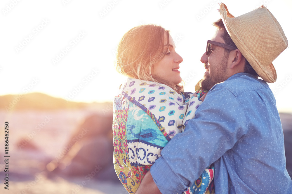 Naklejka premium Happy couple, hug and love outdoor with connection, blanket and bonding together for summer holiday. Space, people and embrace with affection, commitment or healthy relationship on romantic vacation.