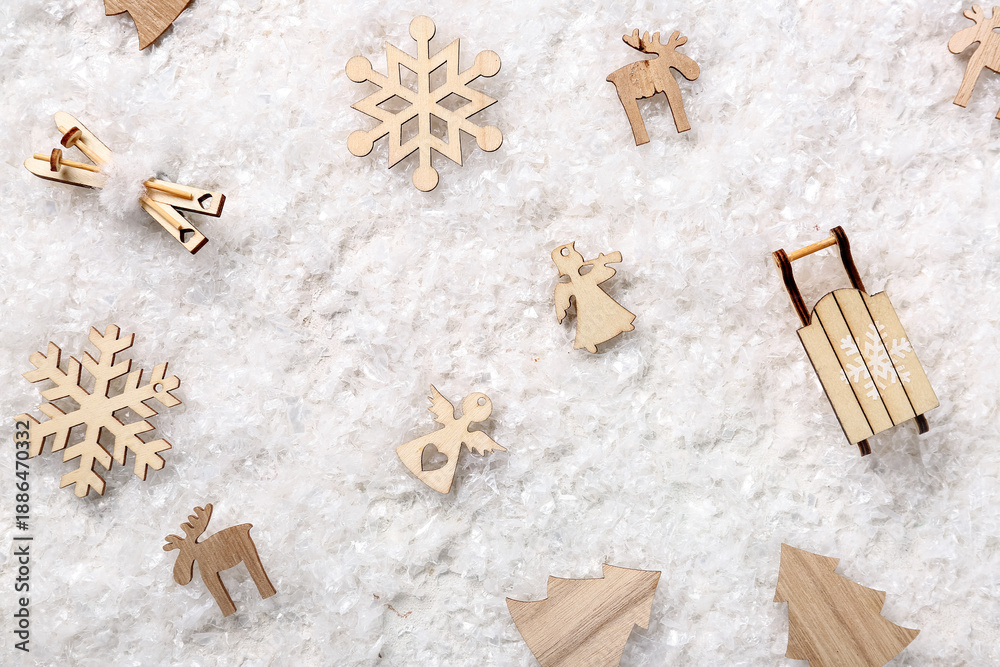 Fototapeta premium Composition with different Christmas wooden toys on decorative snow as background, closeup