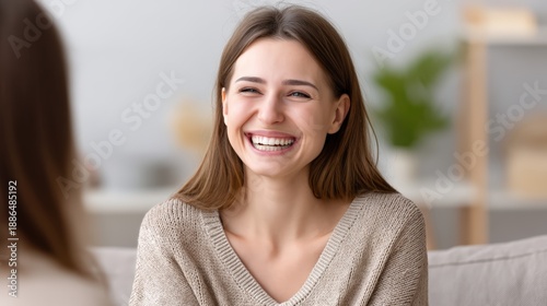 Free Download Authentic scene of emotional support during a therapy session, client laughing softly after a difficult moment, warm ambient lighting, cozy therapy room with soft tones, visible props like tissue box - GFXLoad