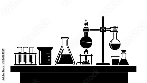 Laboratory equipment with beakers flasks and test tubes on a table.