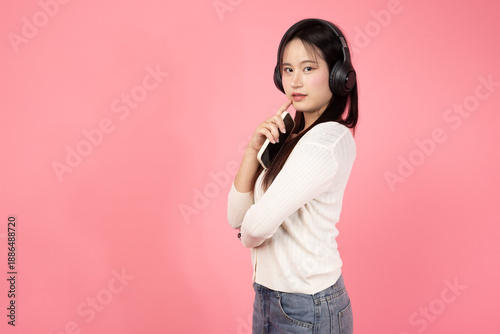 Happy Thai smiling confident A woman wearing headphones and holding a cell phone