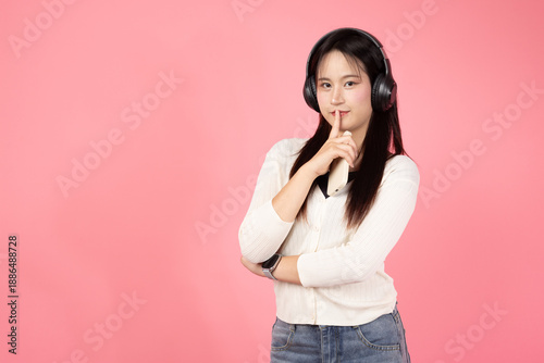 Happy smiling confident A woman in a white shirt and jeans is standing in front of a pink background