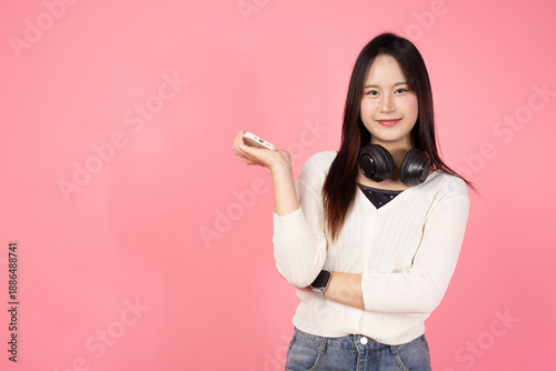 Happy smiling confident woman is holding a cell phone and wearing headphones