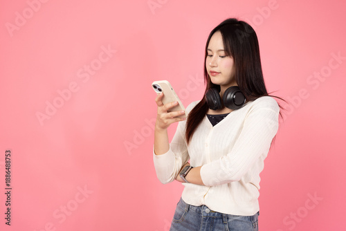 Happy smiling confident A woman is looking at her cell phone while wearing headphones