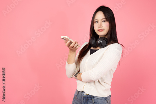 Happy smiling confident A woman is holding a cell phone and wearing headphones