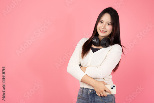 Happy Thai smiling confident A woman is holding a cell phone and wearing headphones