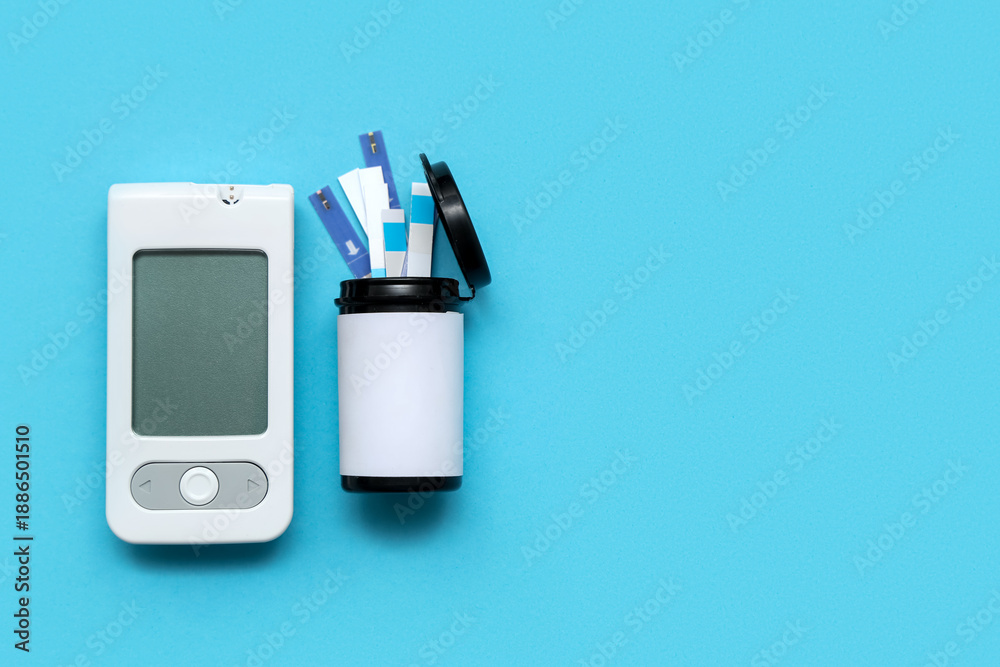 Naklejka premium White digital glucometer and box with test strips on blue background