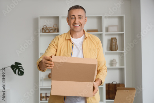 Mature man opening cardboar...