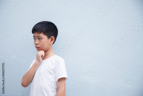 The boy is deep in thought, against a gray background with space for text.