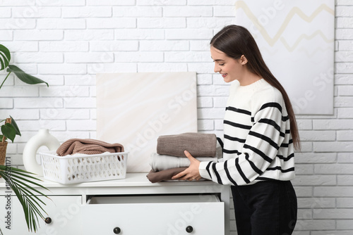 Young woman putting stack o...
