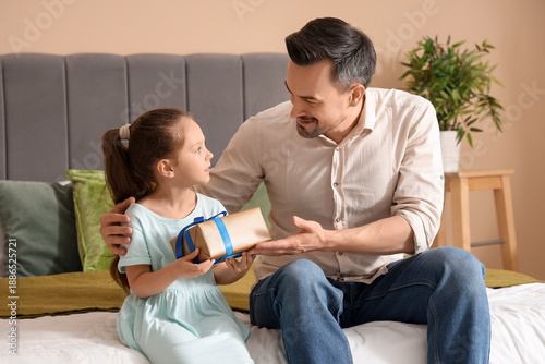 Father giving wrapped gift ...