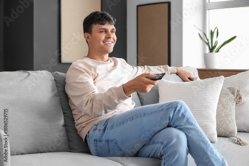 Young man watching TV on so...