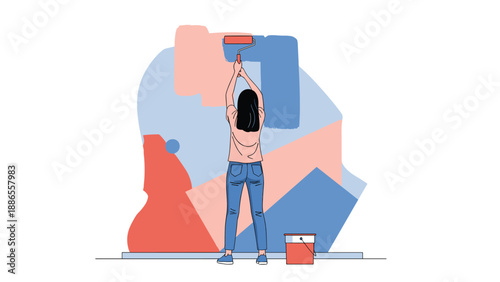 Back view of a young woman painting an abstract geometric mural on a wall with a roller and a paint bucket.