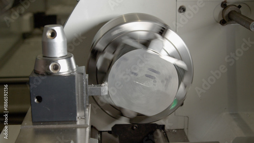 CLOSE UP: Small piece of aluminium is spun by a CNC machine to shave its edges
