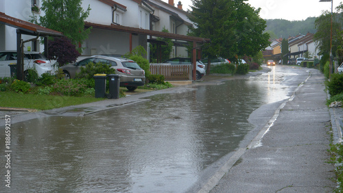 Fényképezés Rainwater covers the road running past terraced houses in the tranquil suburbs