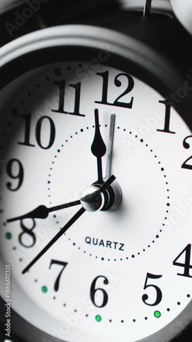 Time ticking on old fashioned alarm clock with bells. Charming black clock ticks steadily, marking every second with grace. Time concept. Clock running fast. Close-up in 4K, UHD