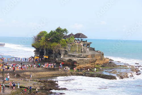 Foto Scenic View of Tanah Lot Temple with Tourists and Ocean Waves in Bali