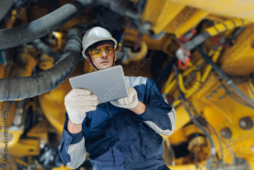 Slika na platnu Male engineer in mining industry with tablet under machinery