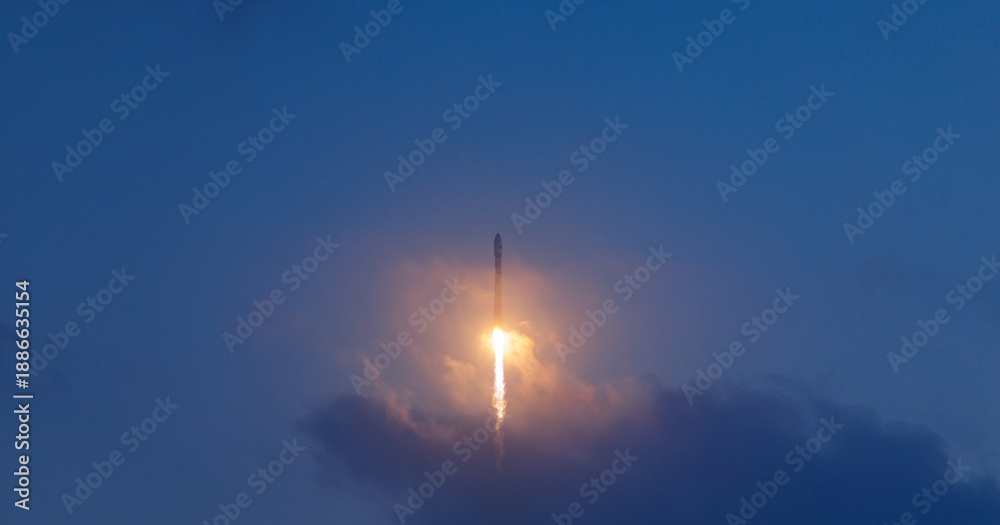 Fototapeta premium Rocket launch illuminating evening sky with glowing trail, aerospace program concept