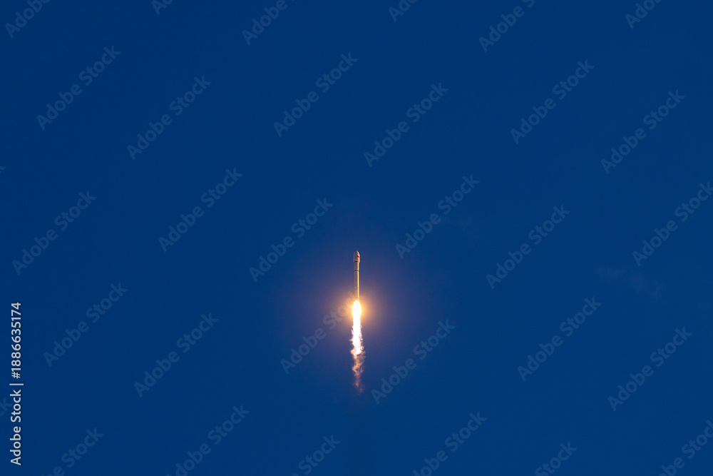 Fototapeta premium Rocket launch against clear blue sky with bright flame trail
