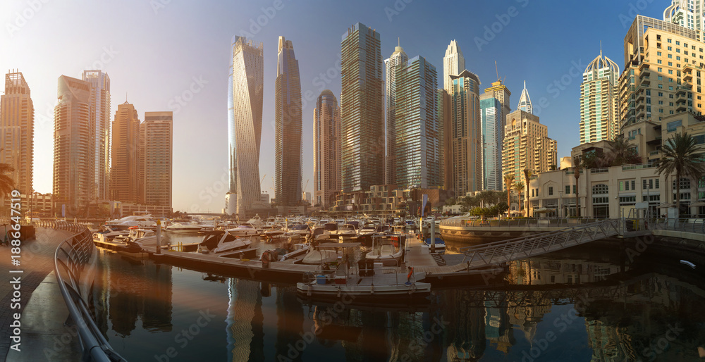 Fototapeta premium Evening view of the city. Orange sunlight, skyscrapers, buildings, and city streets. On the streets of the Emirates, in a public space.