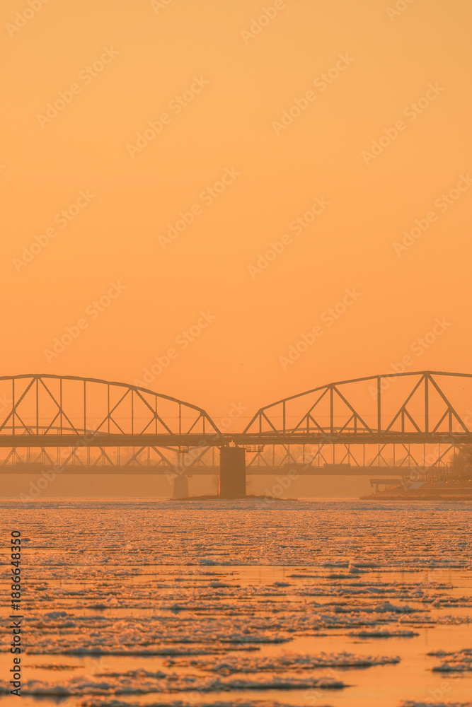 Obraz premium View of the road and railway bridges of the city of Torun at sunset
