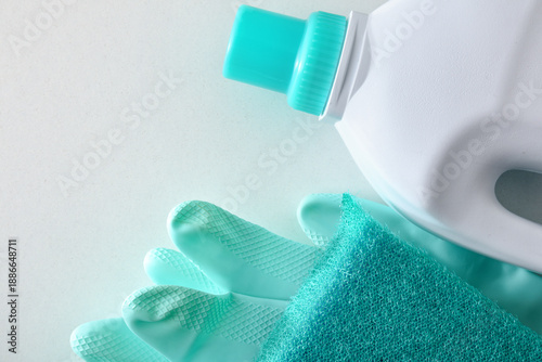 Fotografia disinfectant with scouring pad and green gloves on white table