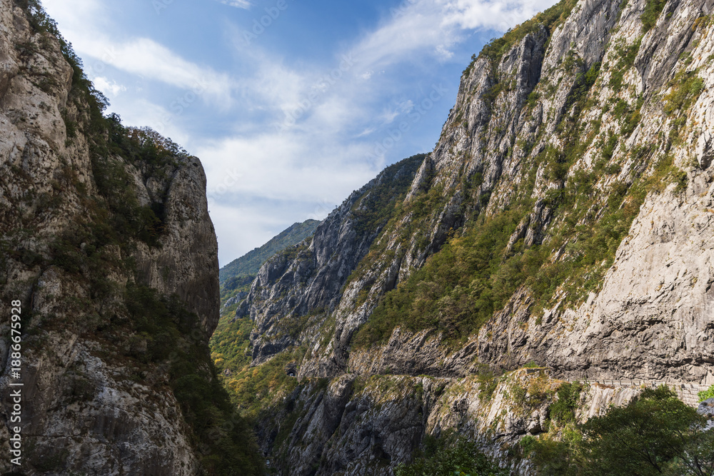 Naklejka premium A dramatic mountain gorge features towering rocky cliffs