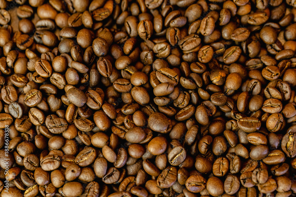 Fototapeta premium Coffee beans background with rich brown tones and natural texture. Roasted coffee beans close-up, creating a warm and aromatic backdrop ideal for coffee shops, cafes, menus, packaging, branding, food 