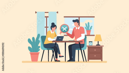 Two people at a table, one with a laptop, one holding a cross symbol