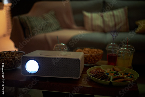 Cuadro en lienzo Closeup showing digital projector on table projecting light with bowls of popcor