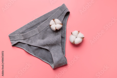 Billede på lærred Women's gray ribbed panties with cotton flowers on pink background, flat lay top view