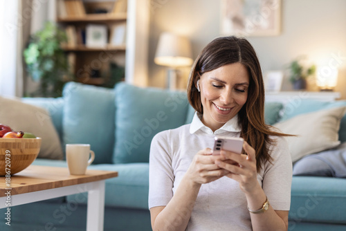 Woman, mobile and smile in home with social media, reading blog and interaction in online dating profile. Girl, happy or phone in living room for comfort, streaming video and typing for text message.