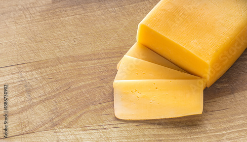 Tableau sur toile piece of cheese close-up on a wooden kitchen board