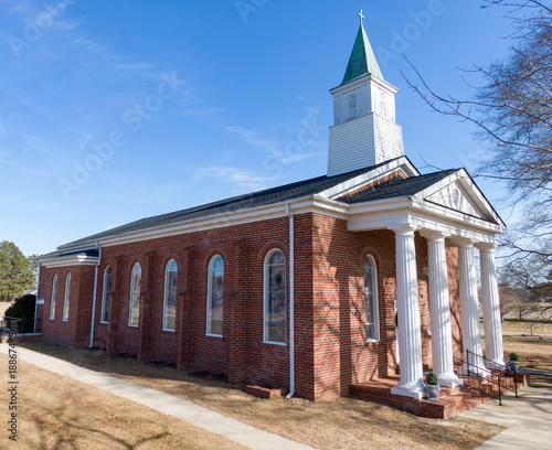 Quadro em tela Classic Southern Baptist Red Brick Church with White Columns and Weathered Coppe