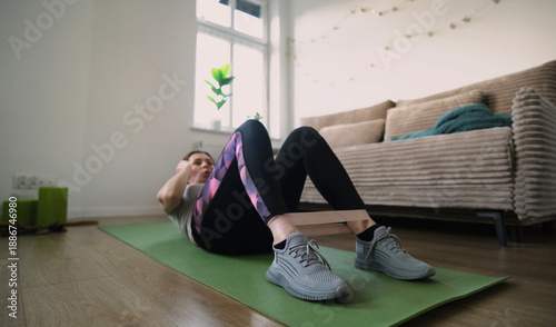 Girl Doing Fitness Exercises With Rubber Resistance Band, Doing Abs Exercises On A Floor
