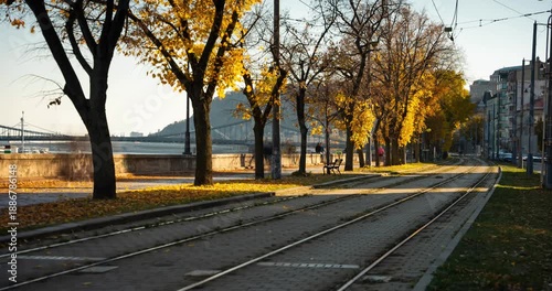 Budapest, Hungary - November 9, 2025: Timelapse. Scenic autumn view of tram tracks along the tree-lined Danube embankment in Budapest Hungary