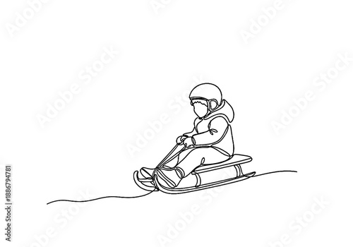 Child sledding down a hill in winter wearing a helmet and coat  