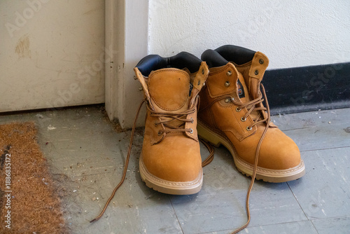 Bilde på lerret Pair of sturdy brown leather work boots on a porch for manual labor construction