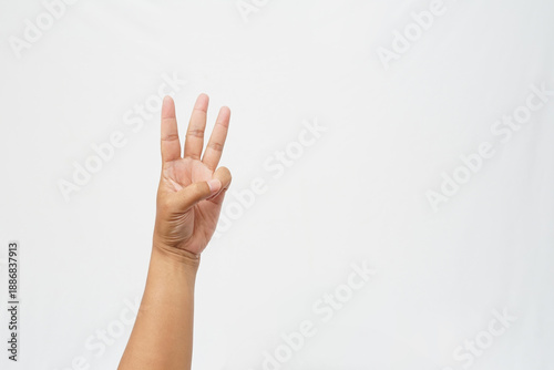 Fotografie Left hand gesturing the number three with three fingers up and thumb holding lit