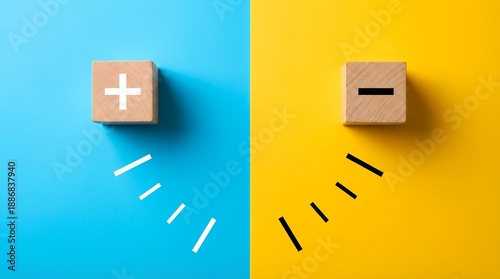 Two wooden cubes with plus and minus symbols displayed on split blue and yellow surfaces with radiating lines sign block comparison contrast choice decision opposite option concept