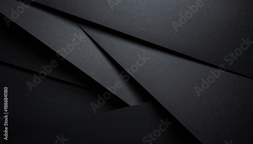 Overlapping dark grey geometric planes with sharp edges and subtle texture