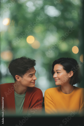 Romantic cinematic couple smiling at each other in cozy outdoor bokeh setting, warm mood and intimate connection