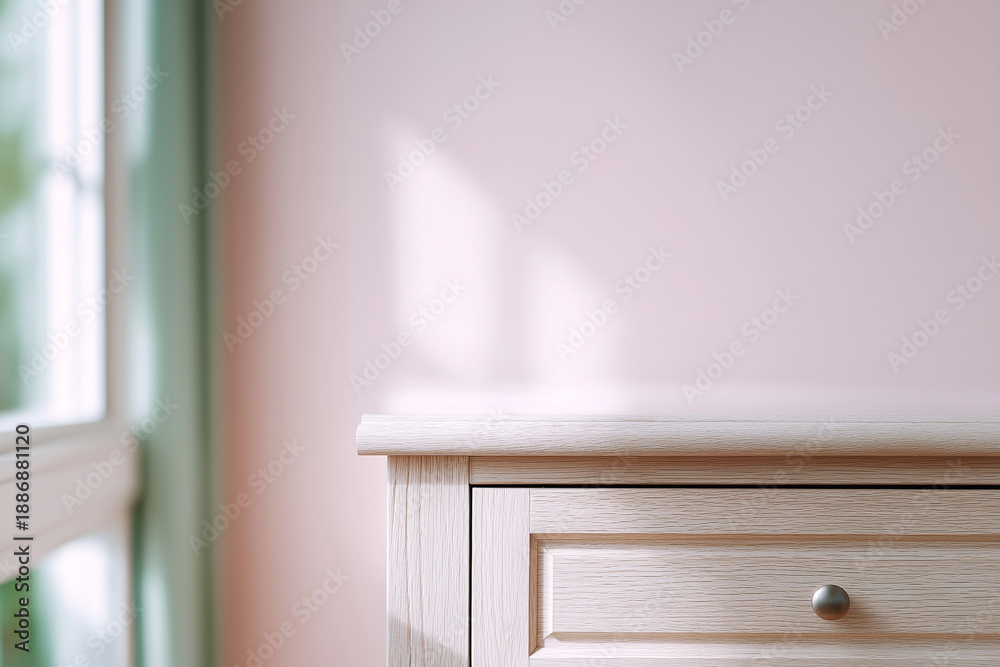 Fototapeta premium Light wood dresser drawer with soft window light casting shadows on a pink wall