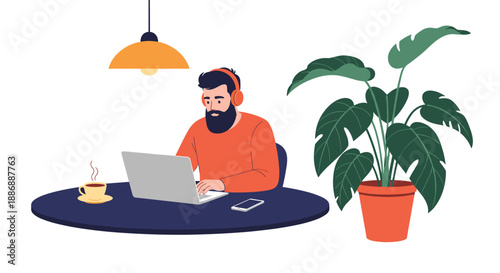 Man with a beard wearing headphones and working on a laptop at a round table next to a large potted monstera houseplant.