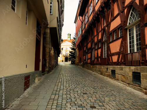 This dark alley leads to a big building in bright sun light.