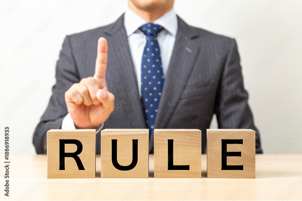 Obraz premium 「RULE」と書かれたブロックとビジネスマン