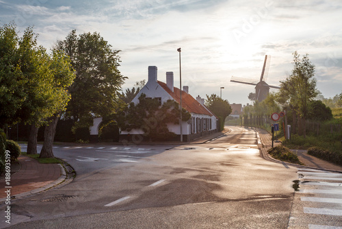 Street with white houses and windmill during the sunset in Knokke, West Vlaanderen, Belgium, Europe